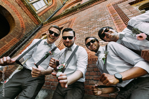 Funny groomsmen in the sunglasses and bow-ties photo