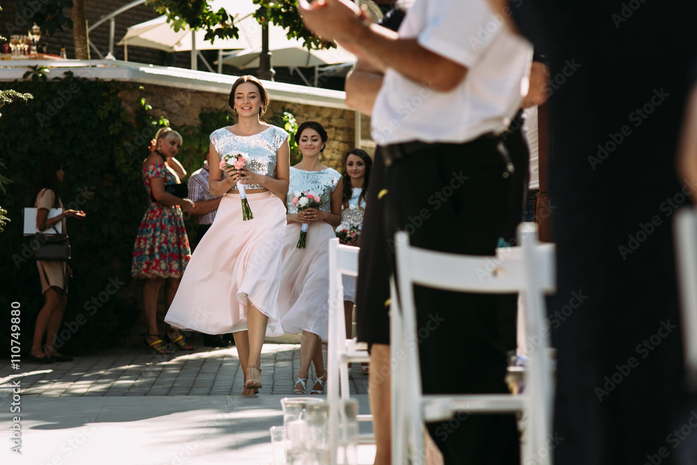 Fototapeta premium Beautiful bridesmaids are walking on the wedding ceremony