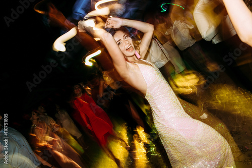 Фотография Joyful dance of the bride in the glamorous evening dress