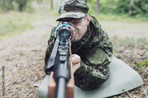 close up of soldier or sniper with gun in forest