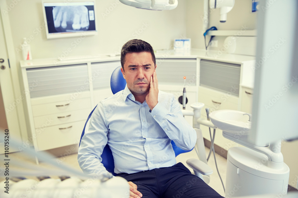 man having toothache and sitting on dental chair man having toothache and sitting on dental chair