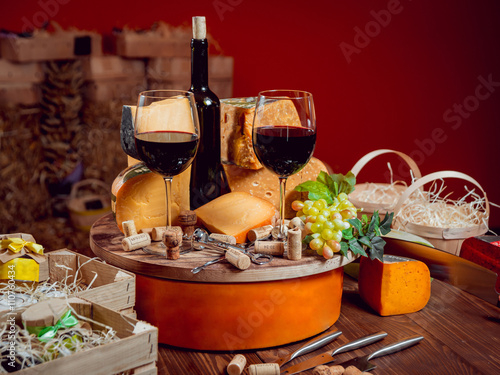 Cheese and wine on a dark table.