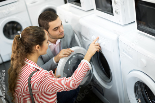 Happy family couple buying new clothes washer photo