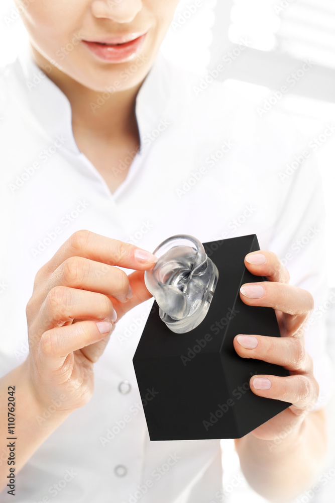 Plastyka uszu.
Kobieta chirurg z sylikonowym odlewem ucha.
