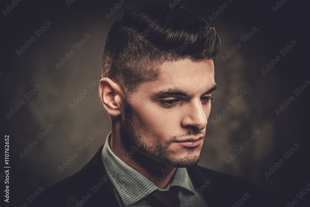 Obraz premium Serious well-dressed hispanic man posing on dark background.