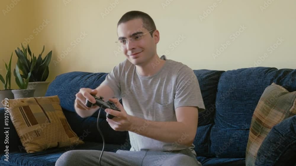 Young adult playing video games in the living room. Young adult playing video games in the living room.