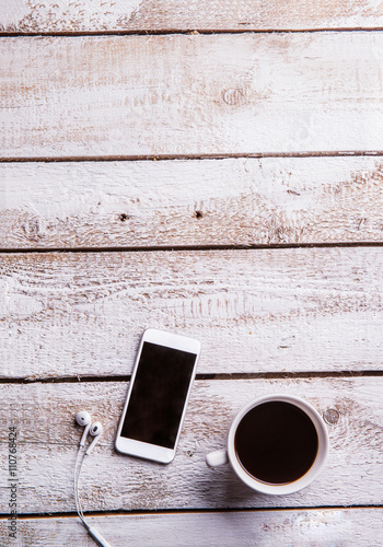 Smartphone, earphones and coffee cup. Flat lay. Copy space.
