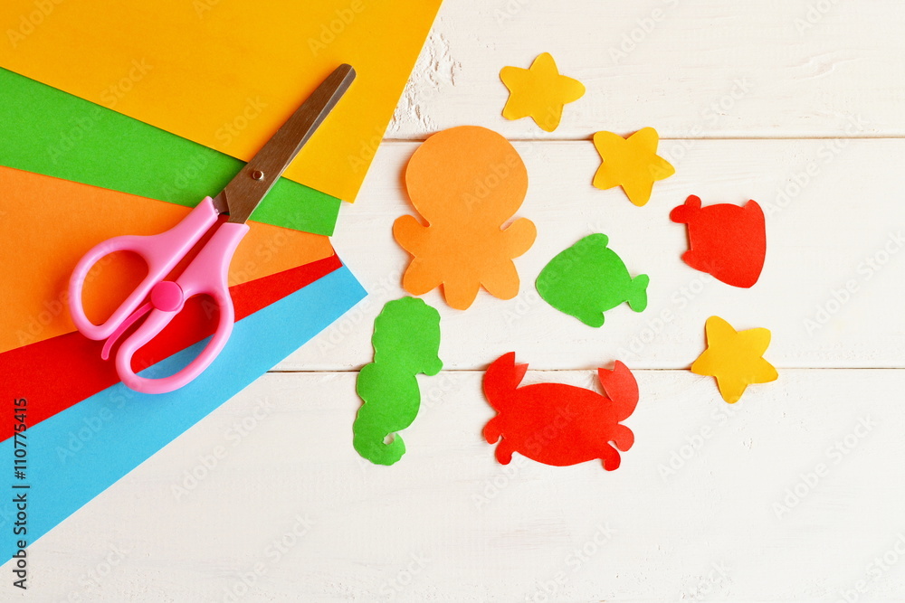 Sheets of colored paper, scissors, glue, paper fish and sea creatures. DIY  concept. Easy kids craft idea. Paper craft Stock Photo