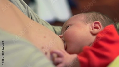 Beautiful one month old baby sucking milk - breastfeeding
