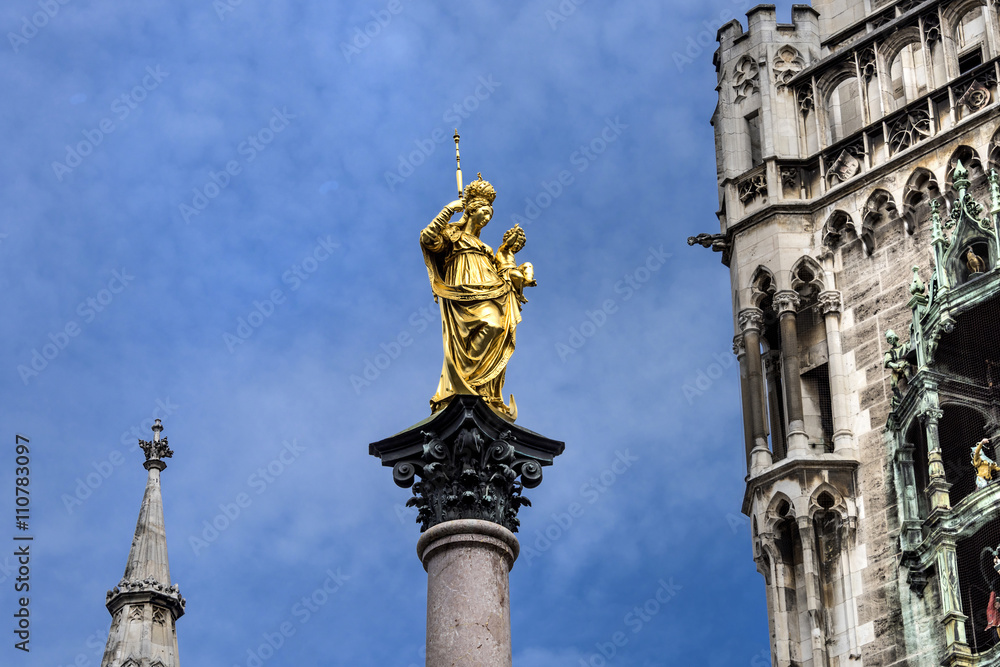 Marienplatz, Munich, Germany: Golden figure of the Marian column with parts of the New Town Hall in the background