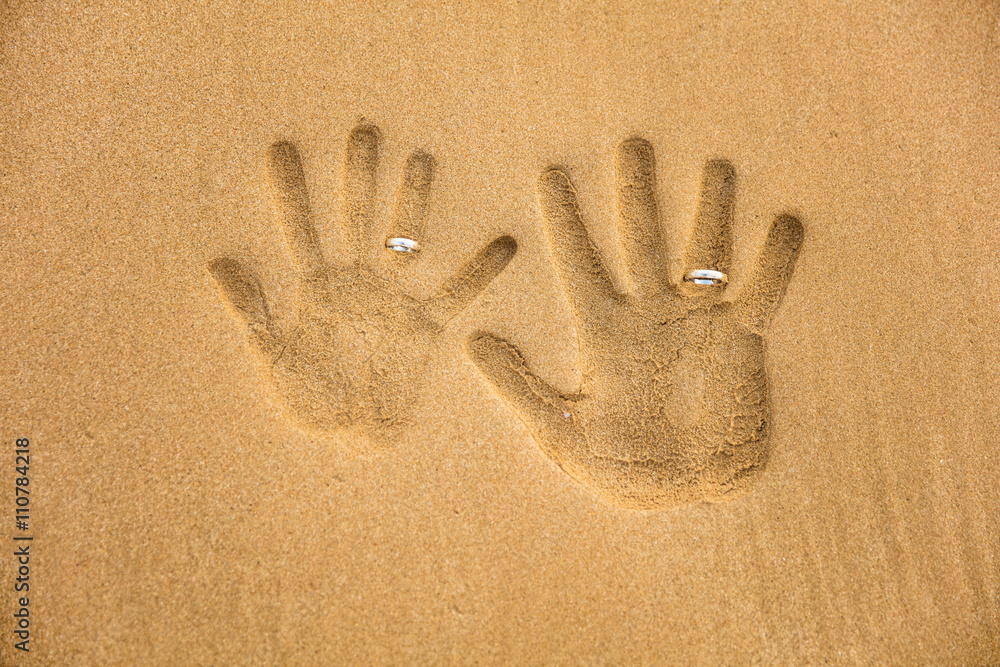 Love handprint with wedding ring on the sand Love handprint with wedding ring on the sand