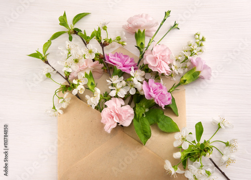 Colorful spring flowers in envelope, flower delivery concept