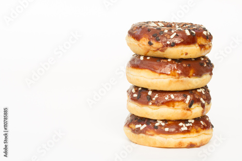 A stack of donuts with chocolate icing and sprinkles on an isolated, white background.