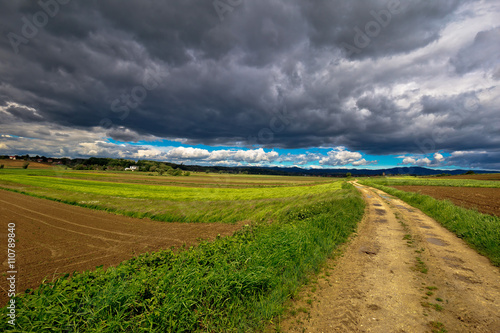 Stormy clouds above countryside road photo