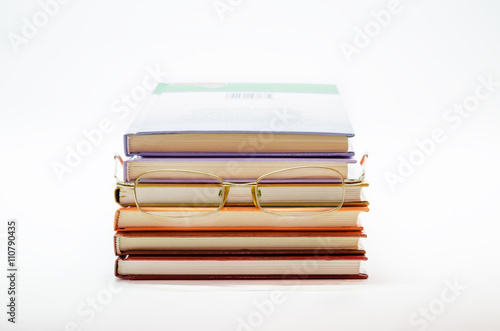 Stack of books with glasses