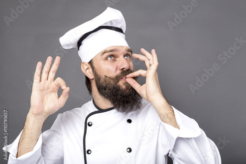 Studio shot of a bearded chef showing OK sign