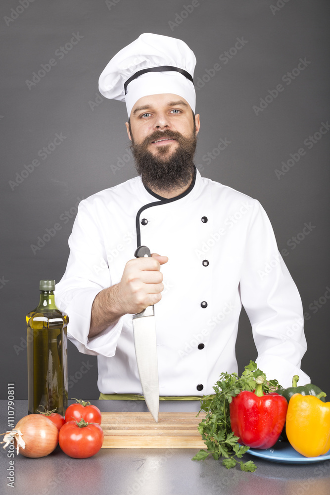 Happy chef holding a big sharp knife on a board ready to cook Happy chef holding a big sharp knife on a board ready to cook