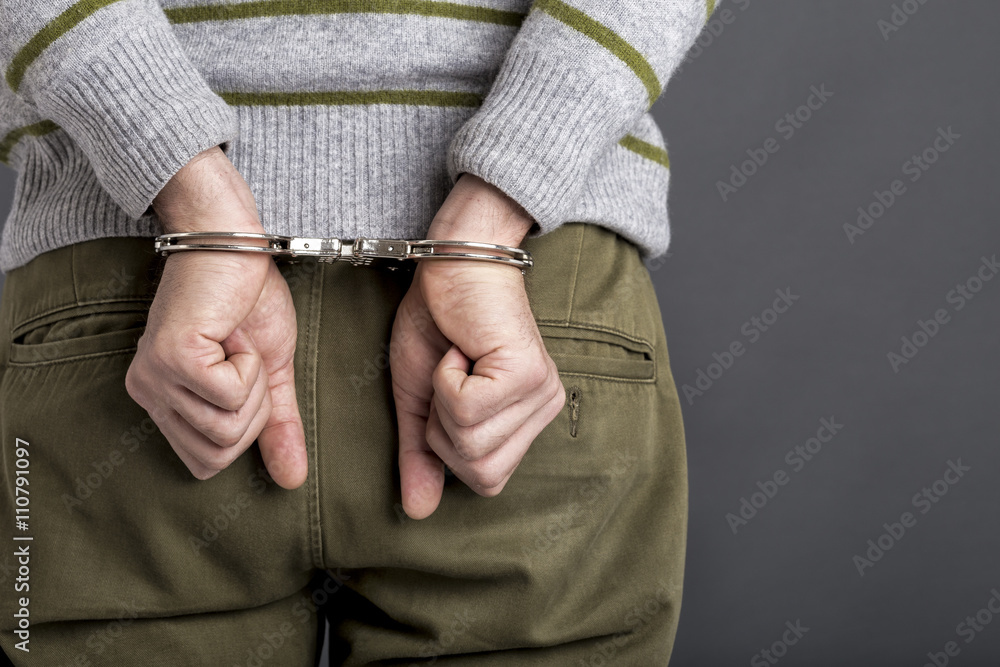 an arrested man with handcuffs an arrested man with handcuffs