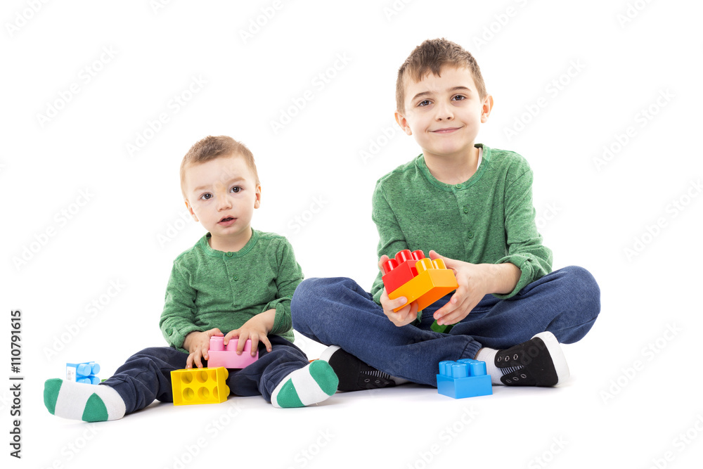 Two brothers playing with colorful cubes on the floor Two brothers playing with colorful cubes on the floor