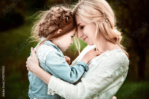 A mother and child in nature. The little girl clung to the mother. The concept of life values, peace, security and love