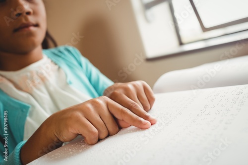 Billede på lærred Girl using braille to read