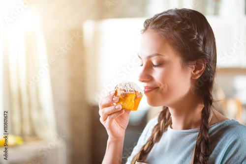 Delighted woman eating maffyn