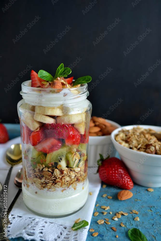 Oatmeal with yogurt, kiwi, banana, strawberries and almonds in a Oatmeal with yogurt, kiwi, banana, strawberries and almonds in a