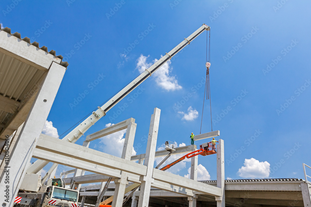 Mobile crane is carry concrete joist to assembly huge hall. Mobile crane is carry concrete joist to assembly huge hall.