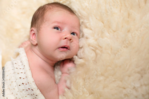 Adorable beautiful newborn baby looking up with a look of wonde