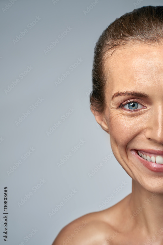 Half face portrait of smiling beautiful middle age woman Half face portrait of smiling beautiful middle age woman
