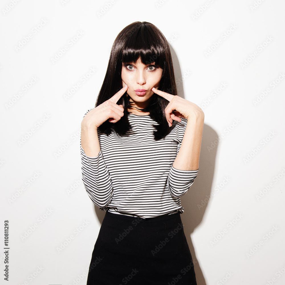 Portrait of beautiful brunette girl, fooling around in the studio on a white background Portrait of beautiful brunette girl, fooling around in the studio on a white background