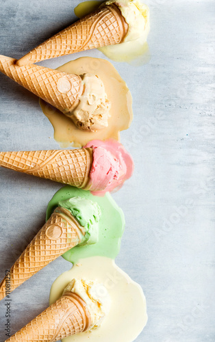 Colorful ice cream cones of different flavors. Melting scoops. Top view   steel metal background