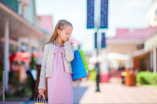 Portrait of little girl shopping outdoors