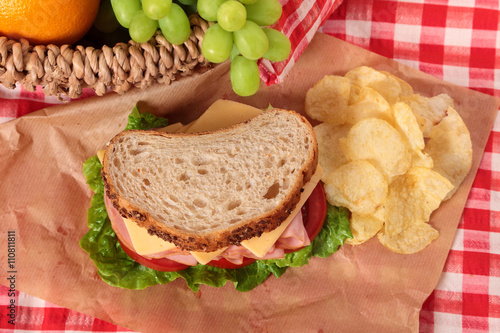 Ham and cheese sandwich with picnic basket , top view
