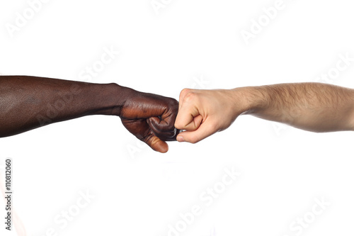 deux poings l'un contre l'autre entre deux hommes de couleurs différentes