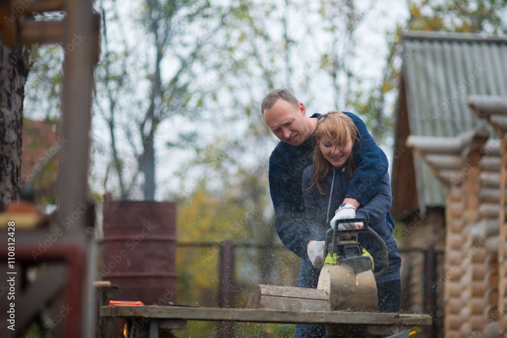 couple in autumn home garden sawing wood couple in autumn home garden sawing wood