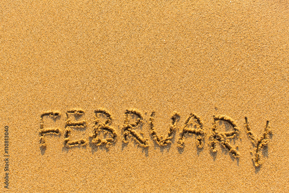 Fototapeta premium February - word inscription on the gold sand sea beach.