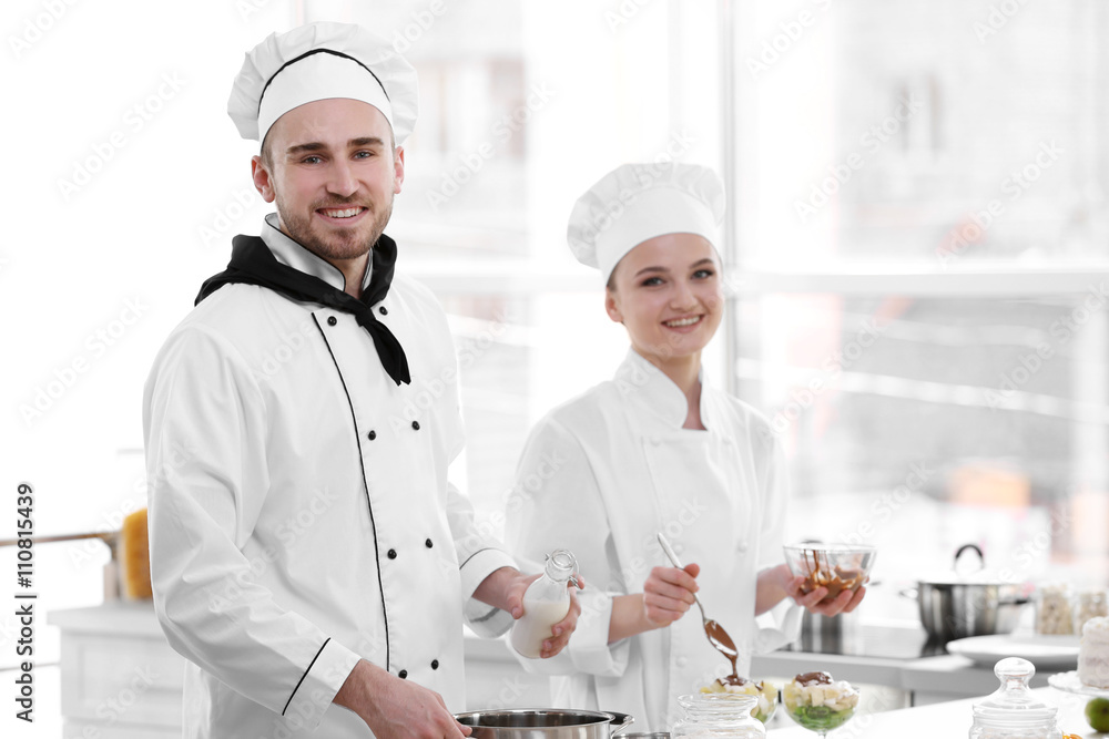 Male and female chefs working at kitchen