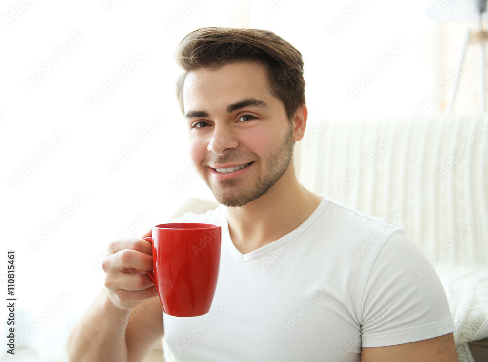 Portrait of young smiling man with red cup of coffee Portrait of young smiling man with red cup of coffee