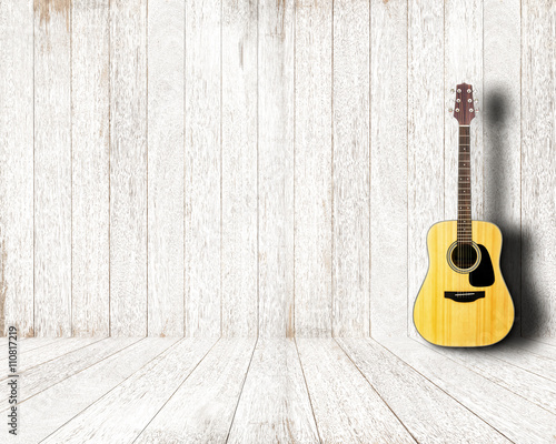 Acoustic guitar in vintage white wood room.