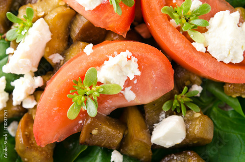 Eggplant salad with tomatoes, feta cheese, spinach and greens