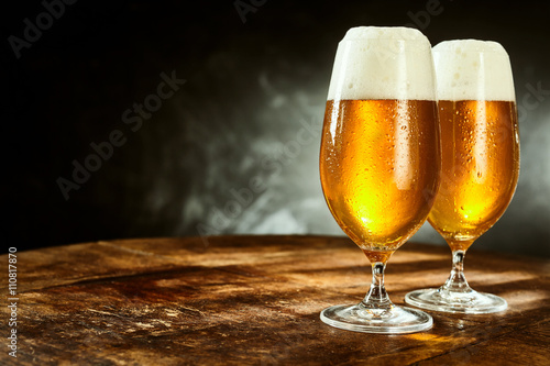 Two glasses full of beer on table photo