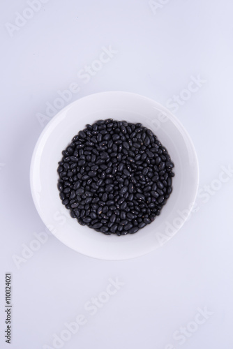 Black soybeans in white bowl on white background