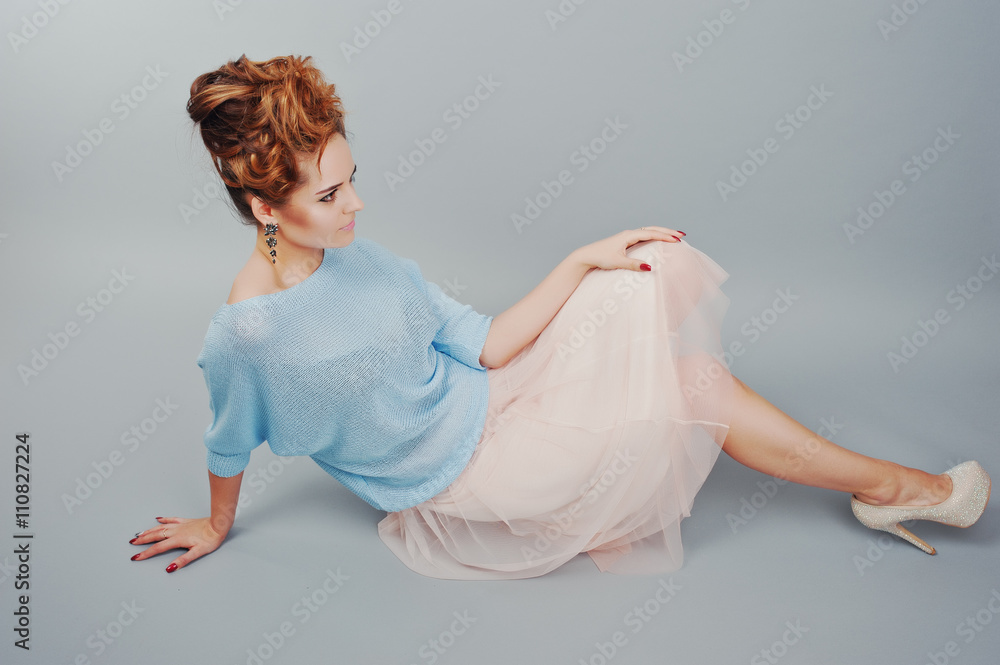 Studio portrait of lying young red haired curly girl at blue blo Studio portrait of lying young red haired curly girl at blue blo