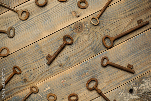 Antique copper keys on old wooden background