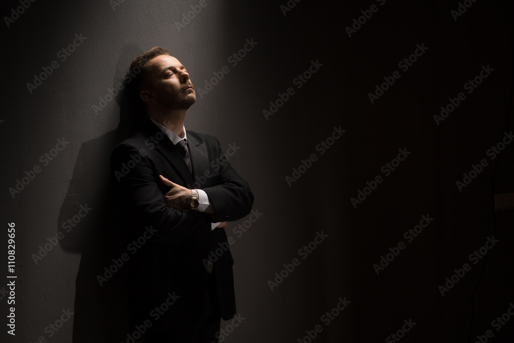 Portrait of successful businessman standing with crossed or folded arms over grey background in studio. Business and executive concepts.
