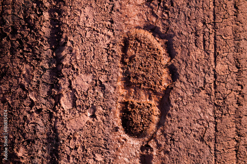 The imprint of the shoe on the muddy dirt road