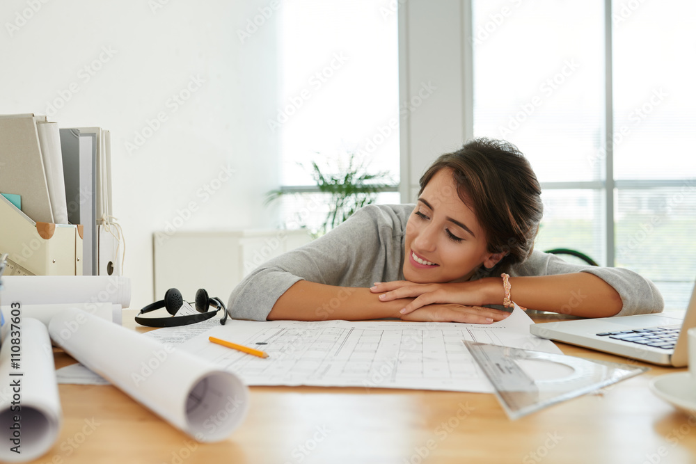 Pretty woman having short break after work with blueprints Pretty woman having short break after work with blueprints