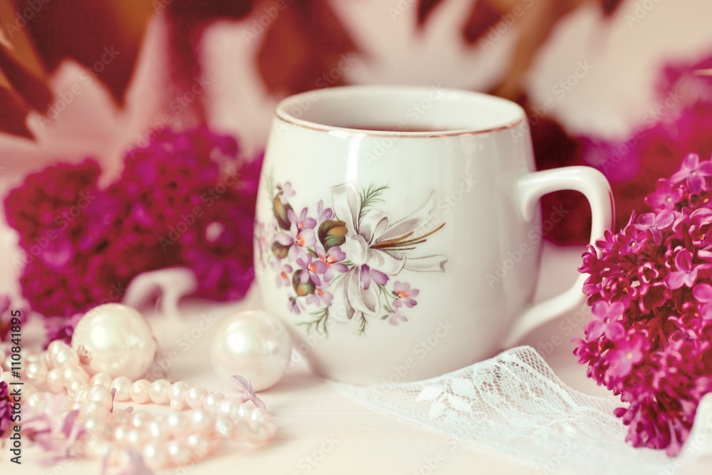 a cup of tea or coffee with a pattern in lilac bouquet of lilacs a cup of tea or coffee with a pattern in lilac bouquet of lilacs
