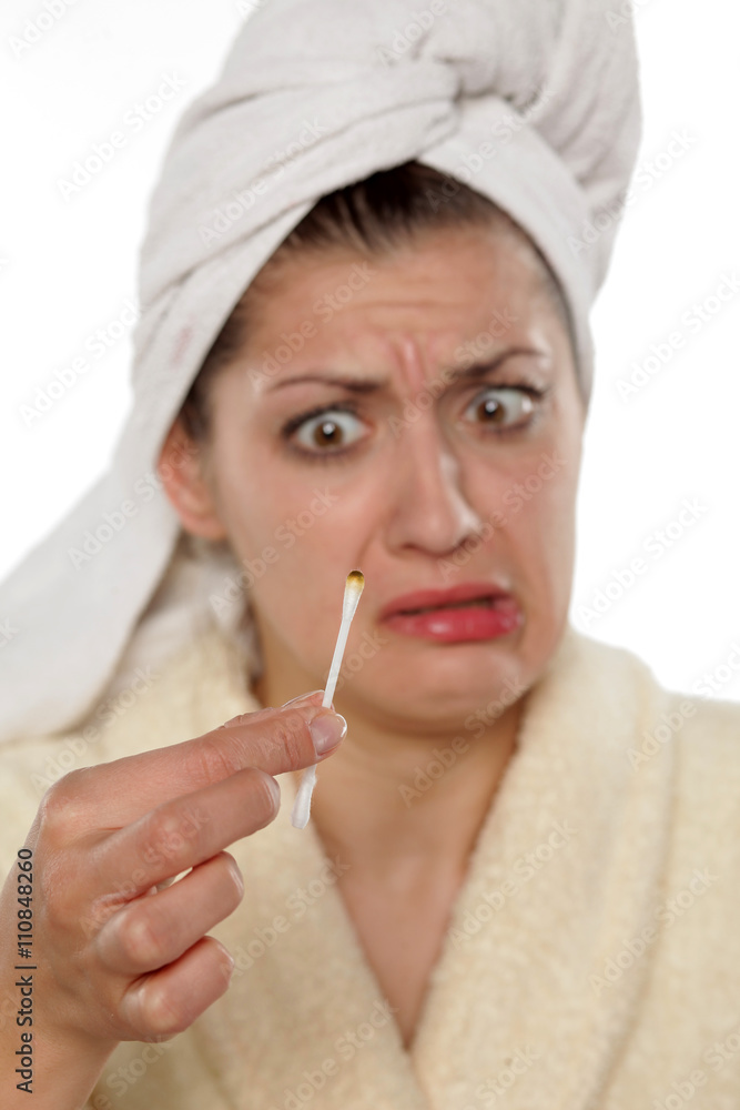 Disgusted young woman with dirty cotton swab in her hand Disgusted young woman with dirty cotton swab in her hand